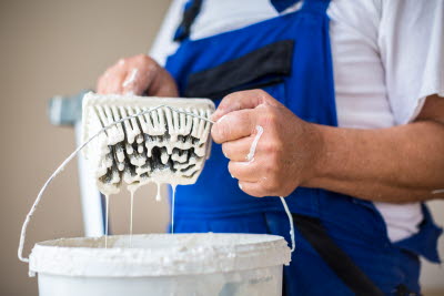 Målare doppar pensel i färgburk