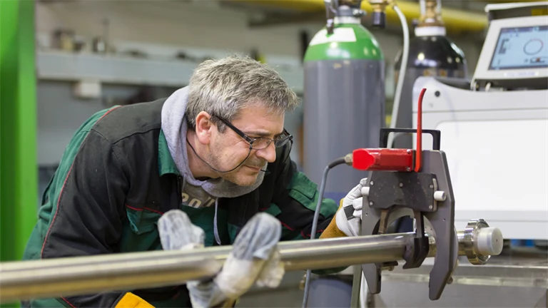 Man inspekterar maskin i fabrik