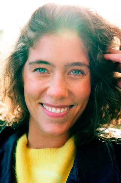 Leende kvinna i gul, stickad tröja