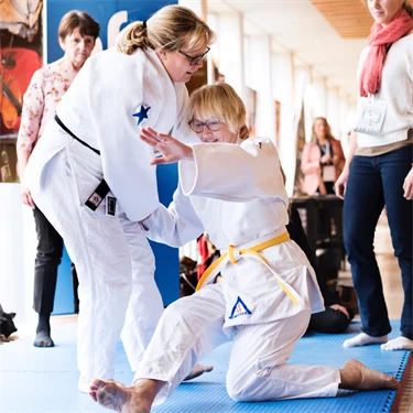 Forskaren och judoinstruktören Karin Strömqvist Bååthe på judomattan tillsammans med annan judotränande person..