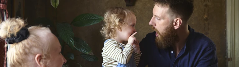 Robert Berg leker med dottern Nanna i sitt knä på Kullzenska caféet. Sambon Rebecca har bebisen Knut i famnen och de ler och tittar på.