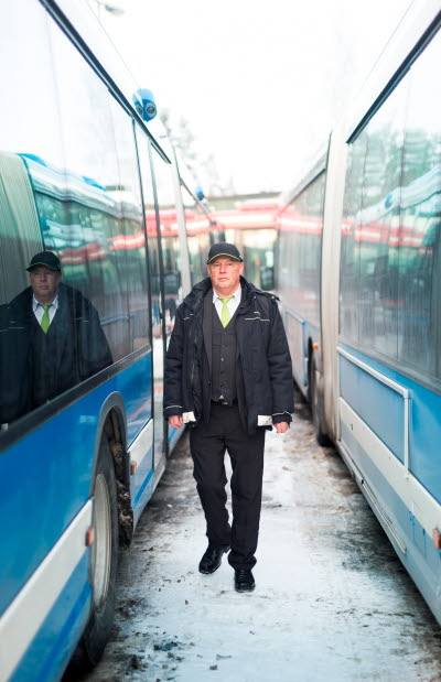 Busschaufför går mellan två bussar