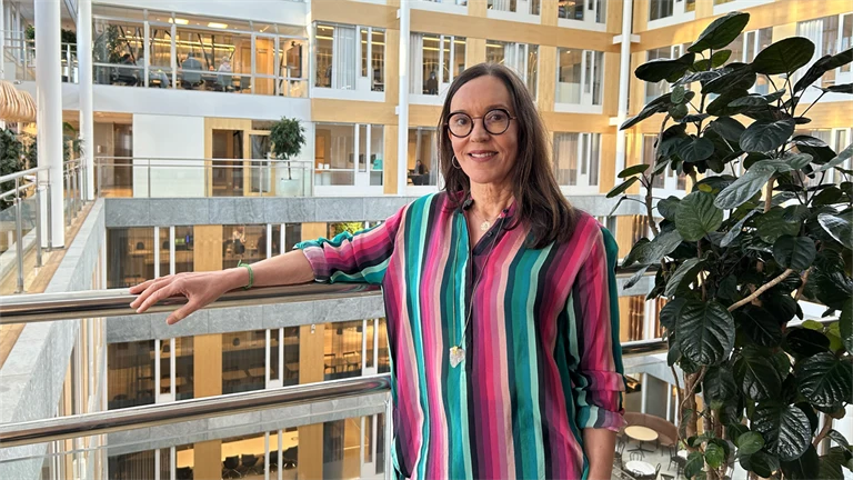 Susanna Toivanen från Mälardalens universitet står mot kontorets innergård. Hon ler mot kameran.