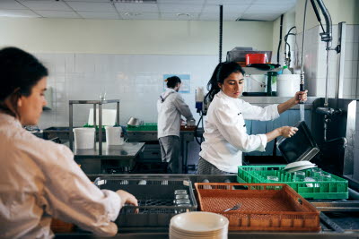 Diskare sköljer disk i storkök