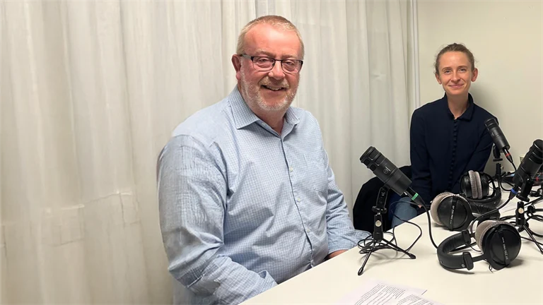 Per Winberg och Jenny Sparring vid ett bord med poddinspelningsutrustning.