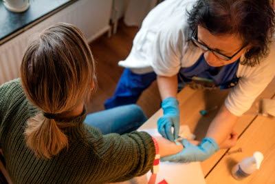 Sjuksköterska sätter infart i en ven på en patient