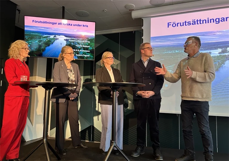 Fem personer står på en scen och har ett panelsamtal.