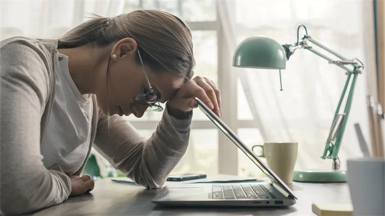 Ung kvinnar lutar sig mot dator