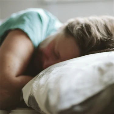 Kvinna som sover med huvudet på en kudde