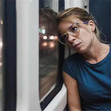en person lutar huvudet mot ett fönster på en buss