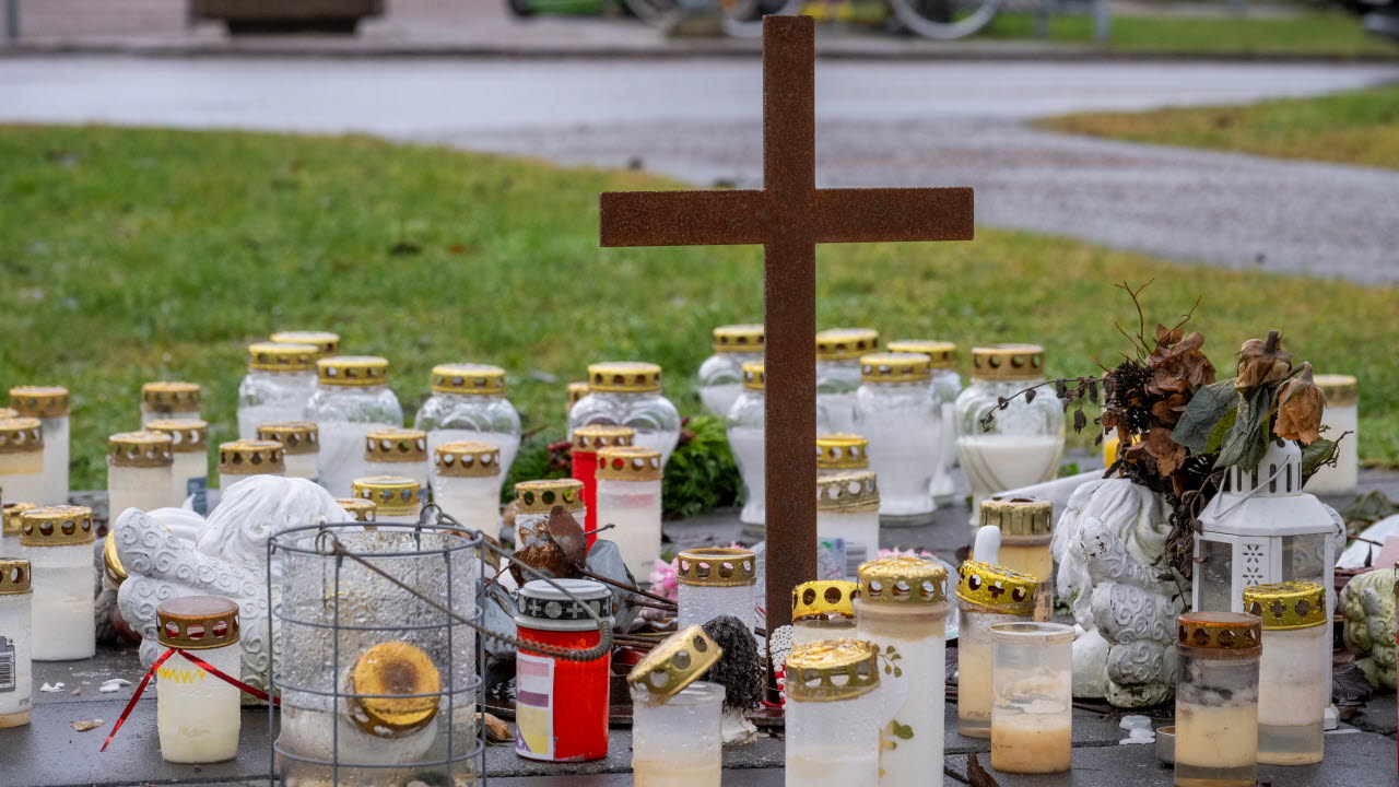 Gravlyktor och ett kors på gräsmattan framför Campus Risbergska.
