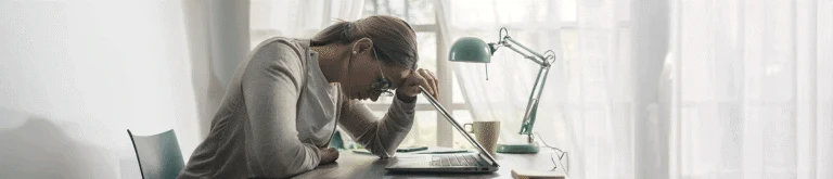 Ung kvinnar lutar sig mot dator