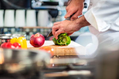 Kock skär grönsaker