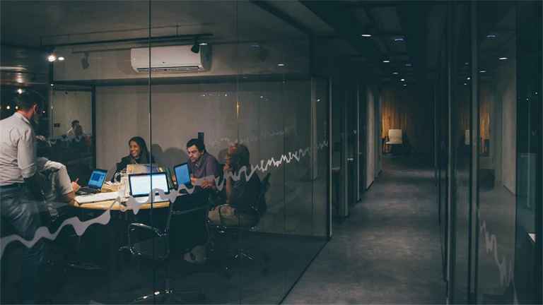 En arbetsgrupp sitter i ett mötesrum och arbetar.
