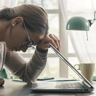 Ung kvinnar lutar sig mot dator