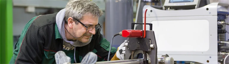 Man inspekterar maskin i fabrik