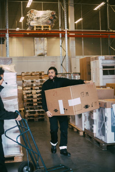 Lagerarbetare bär kartong