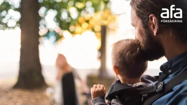 Förälder med barn i sele i skogsparti och Afa Försäkrings logotyp.
