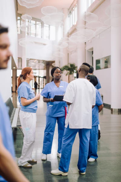 Vårdpersonal står och samtalar i korridor