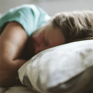 Kvinna som sover med huvudet på en kudde