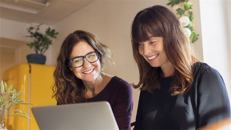 Två personer jobbar framför dator.