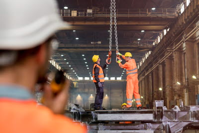 Män fixar med kedja i fabrik