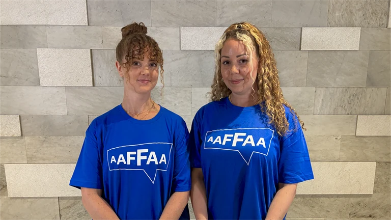 Två Afa-medarbetare i t-shirts från Tänk på oss-kampanen.