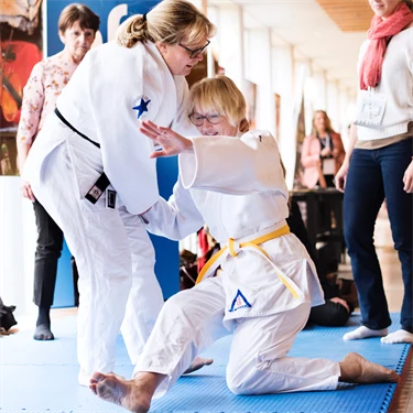 Forskaren och judoinstruktören Karin Strömqvist Bååthe på judomattan tillsammans med annan judotränande person..