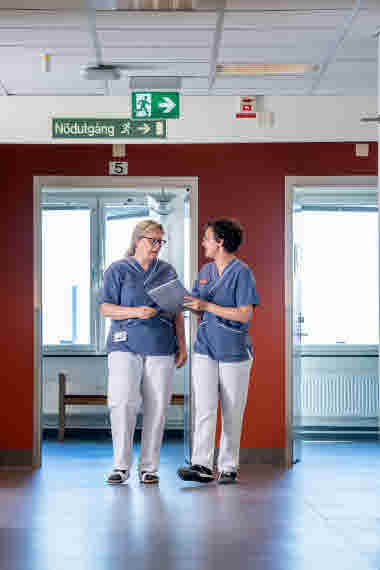 Två sjuksköterskor pratar i korridoren