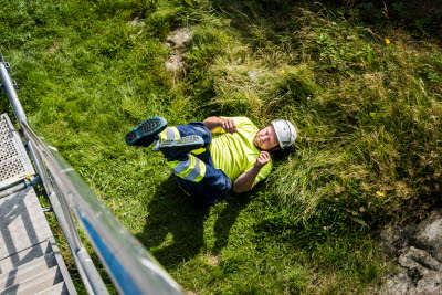 Bygganställd faller faller på marken utomhus