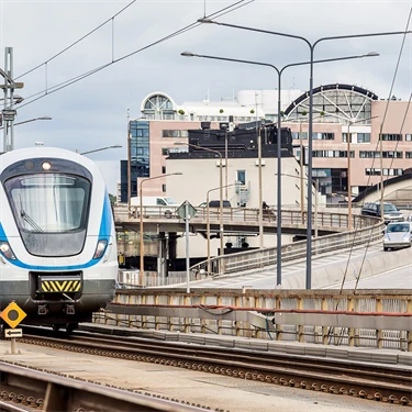 Ett tåg i Sverige rullar in mot en tågstation. 