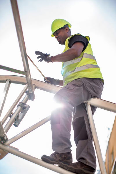 Byggjobbare klättrar på ställning