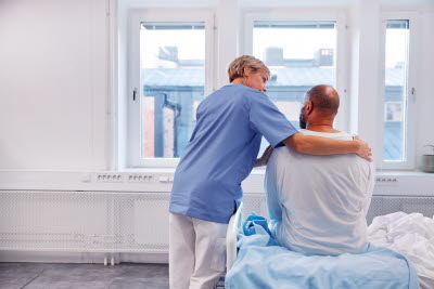 Sjukvårdare håller en patient om ryggen