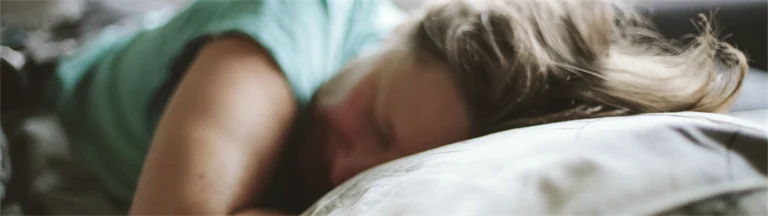 Kvinna som sover med huvudet på en kudde