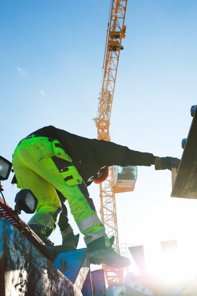 Byggnadsarbetare klättrar på bygget