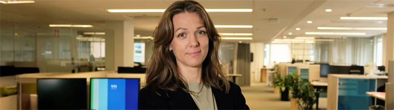 Anna Hääger, hållbarhetsansvarig på Afa Försäkrings Kapitalförvaltning står i ett kontorslandskap.