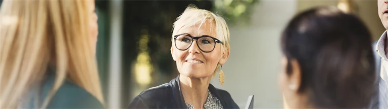 Nöjd kvinna tittar åt sidan under mingel