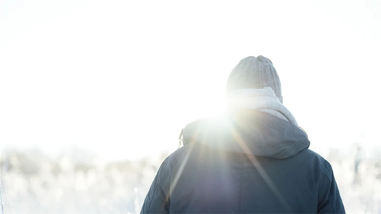 Man promenerar i vinterlandskap