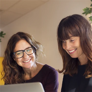 Två personer jobbar framför dator.