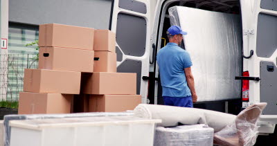 Bud lastar ur kartonger och varor från skåpbil