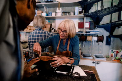 Kvinna arbetar med läder i en verkstad