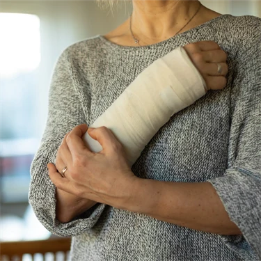 Kvinna med gipsad arm