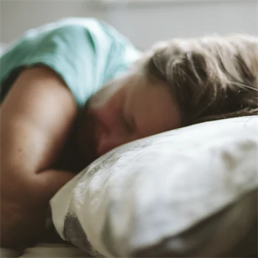 Kvinna som sover med huvudet på en kudde
