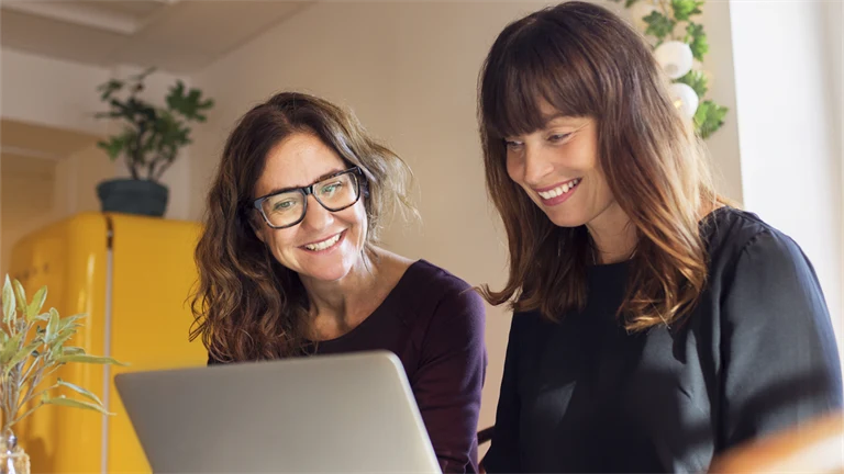 Två personer jobbar framför dator.