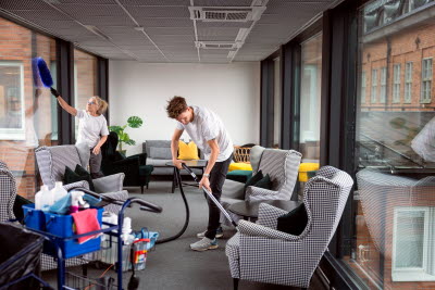 Man och kvinna städar en arbetsplats