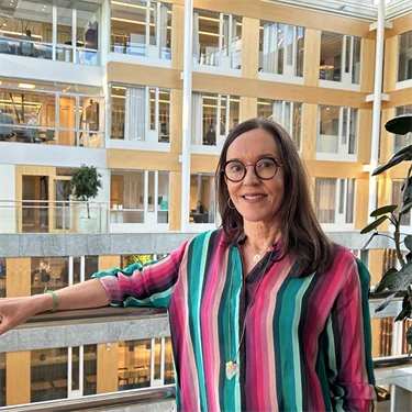 Susanna Toivanen från Afa Försäkring står mot kontorets innergård. Hon ler mot kameran.