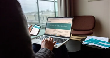 Skrivbord med mobil och laptop som visar Avtalats webbplats.