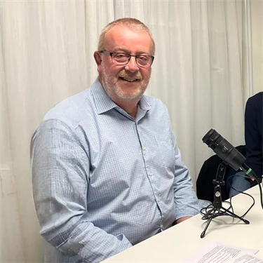 Per Winberg och Jenny Sparring vid ett bord med poddinspelningsutrustning.