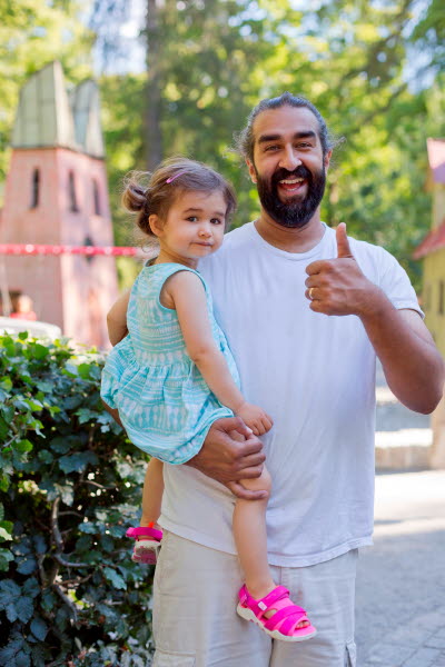 Glad man med flicka på armen, en sommardag