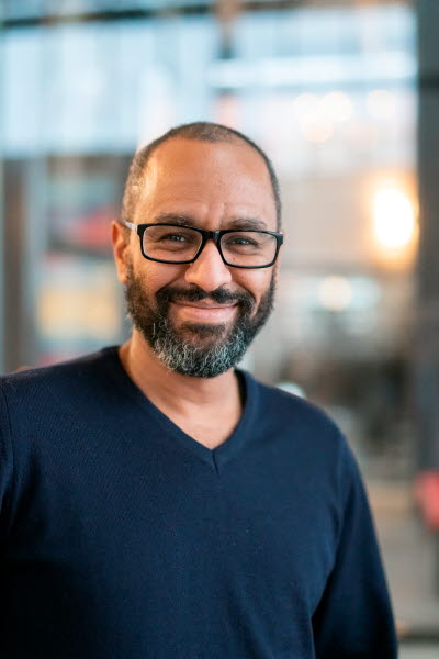 Tunnhårig man med skägg och glasögon